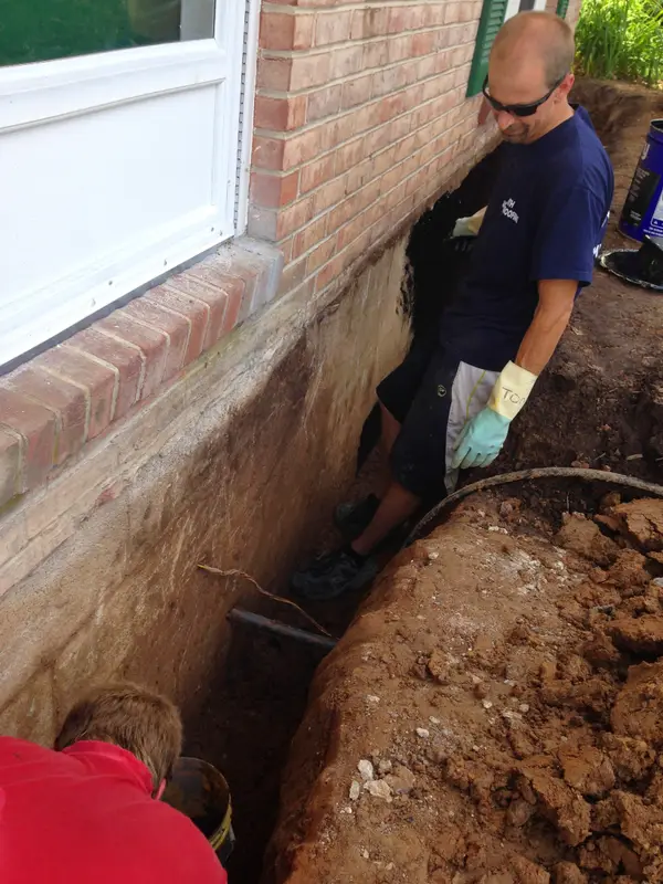 Hand excavation along a residential foundation