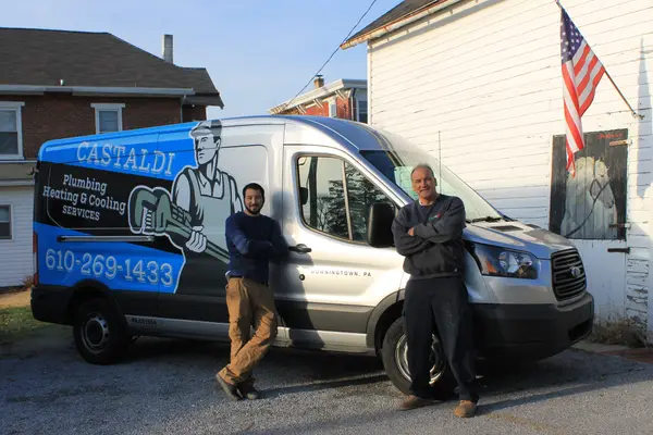 Two Castaldi team members beside their branded service van