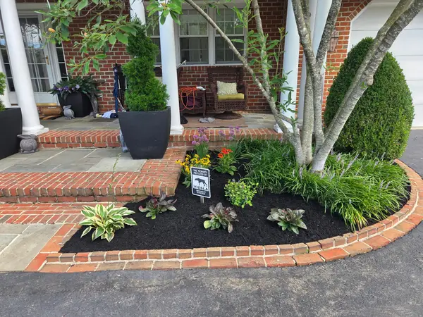Planting bed with brick edging in front of a home