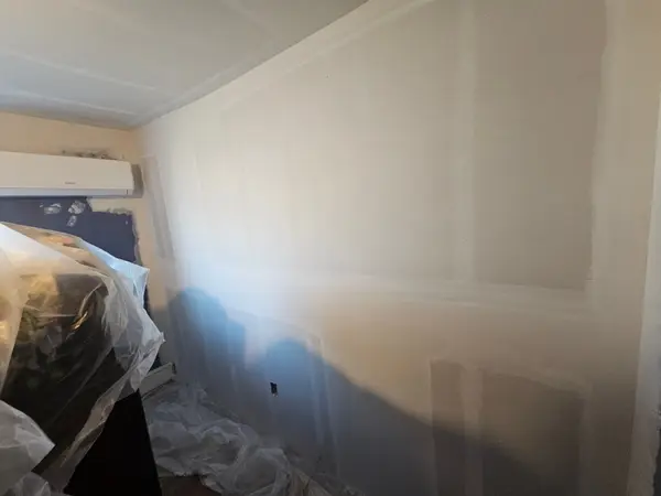 Prepared drywall walls in a bedroom