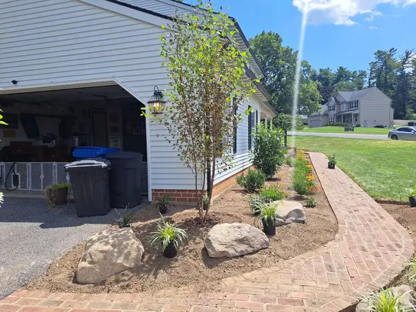 Brick walkway through a landscaped area
