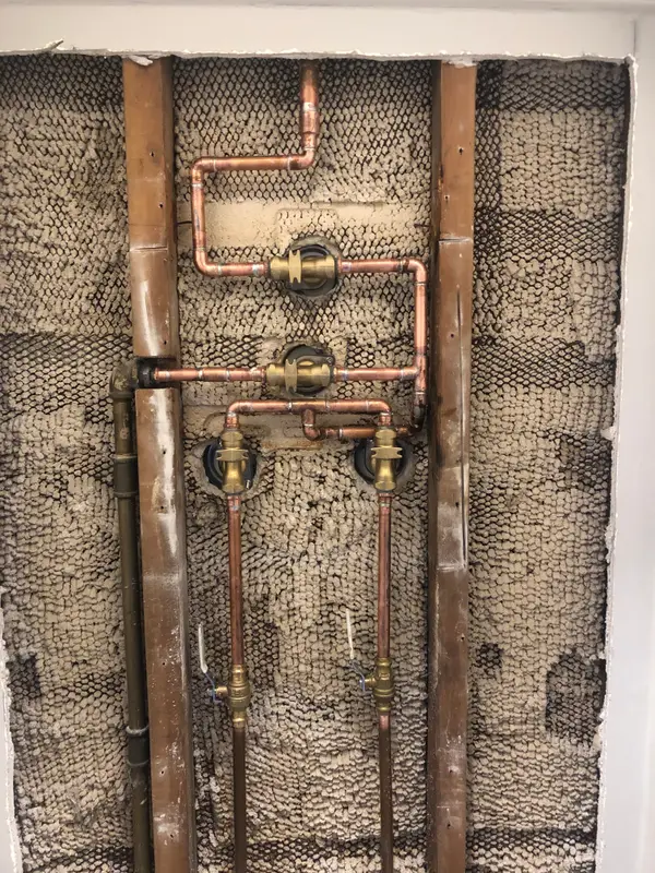 Exposed shower valve and connected pipes