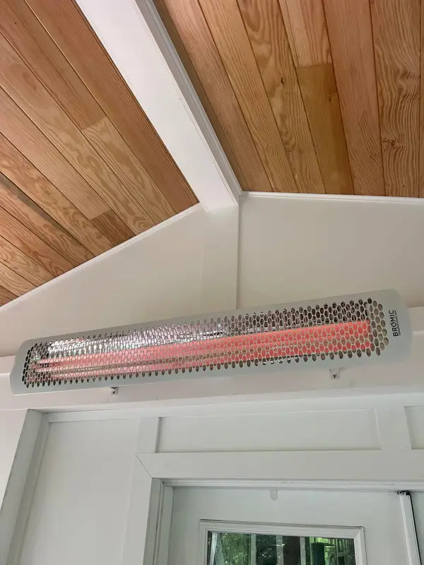 Wall-mounted electric heater below a covered ceiling