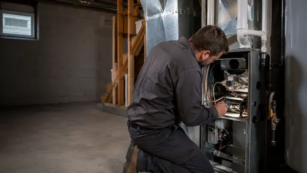 Technician servicing a residential furnace