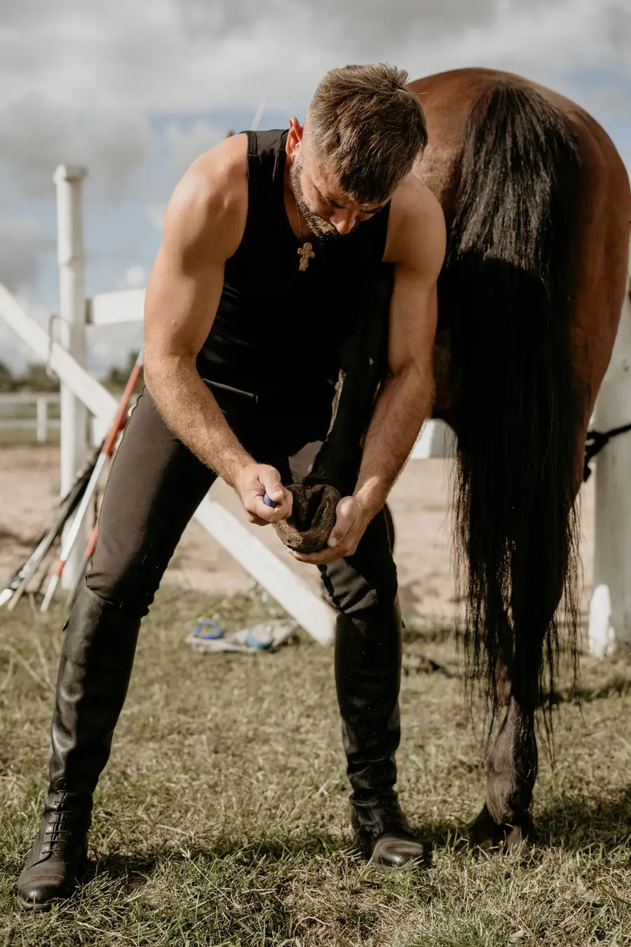 Farrier caring for a horse hoof outdoors