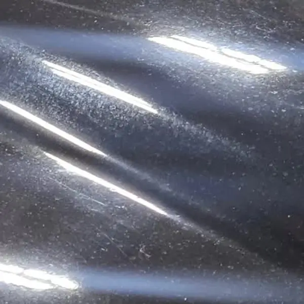 Dark vehicle hood showing swirls and surface marks before JRC Shine paint correction