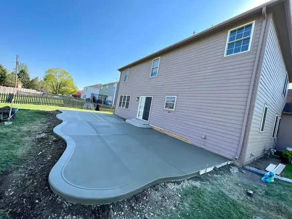 Curved concrete patio beside a house