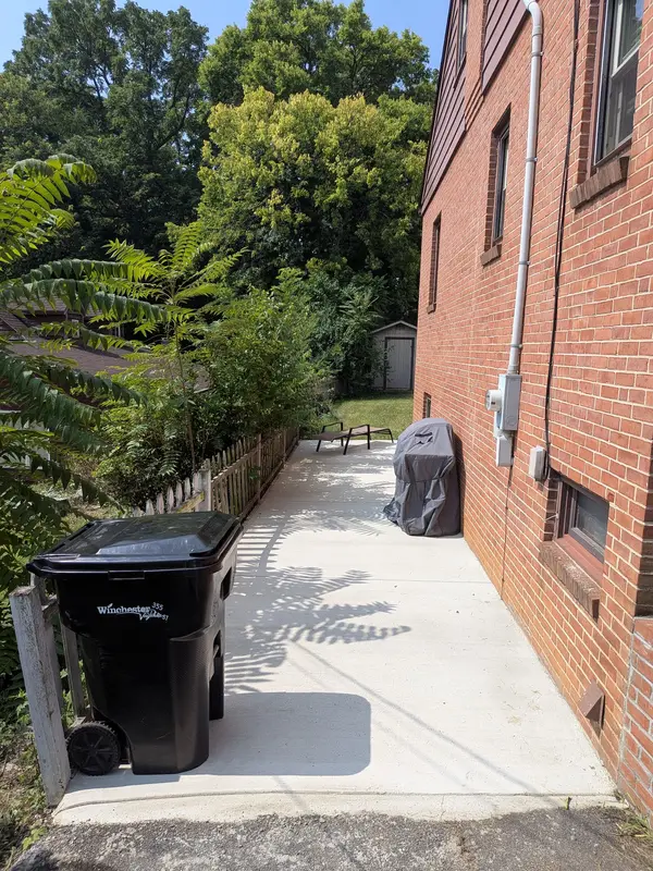 Concrete walkway along a brick home