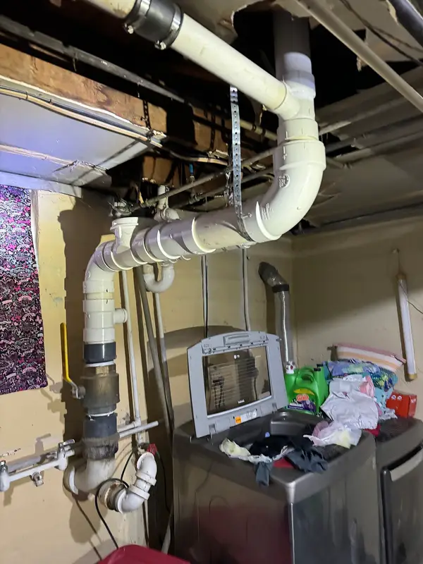 Drain and supply piping below a floor