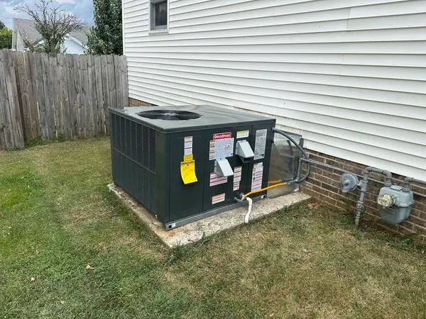 Heating and cooling equipment beside white siding