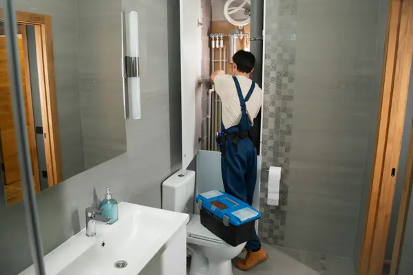Decorative stock photograph of a plumber working in a bathroom