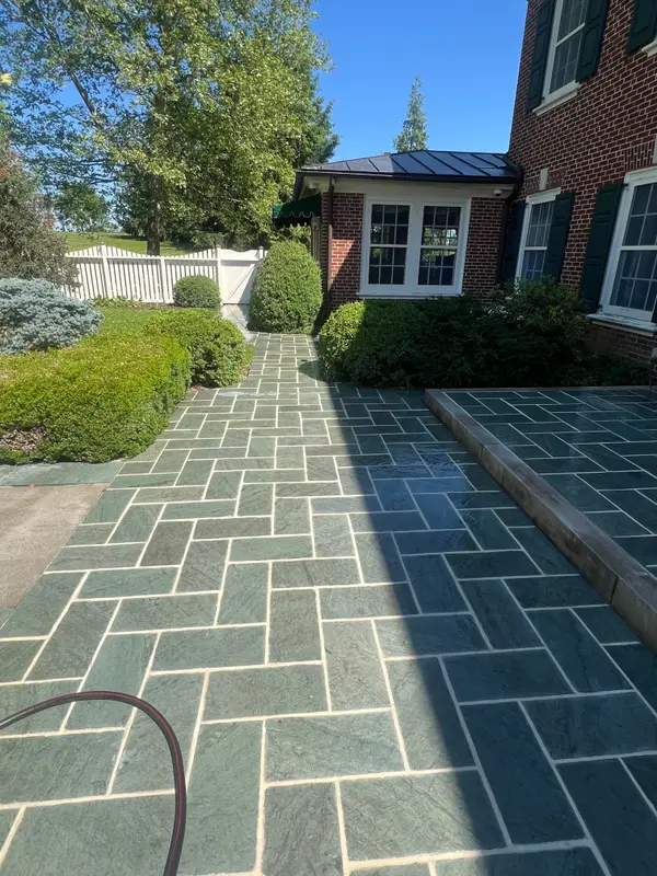 Finished stone walkway beside a brick home